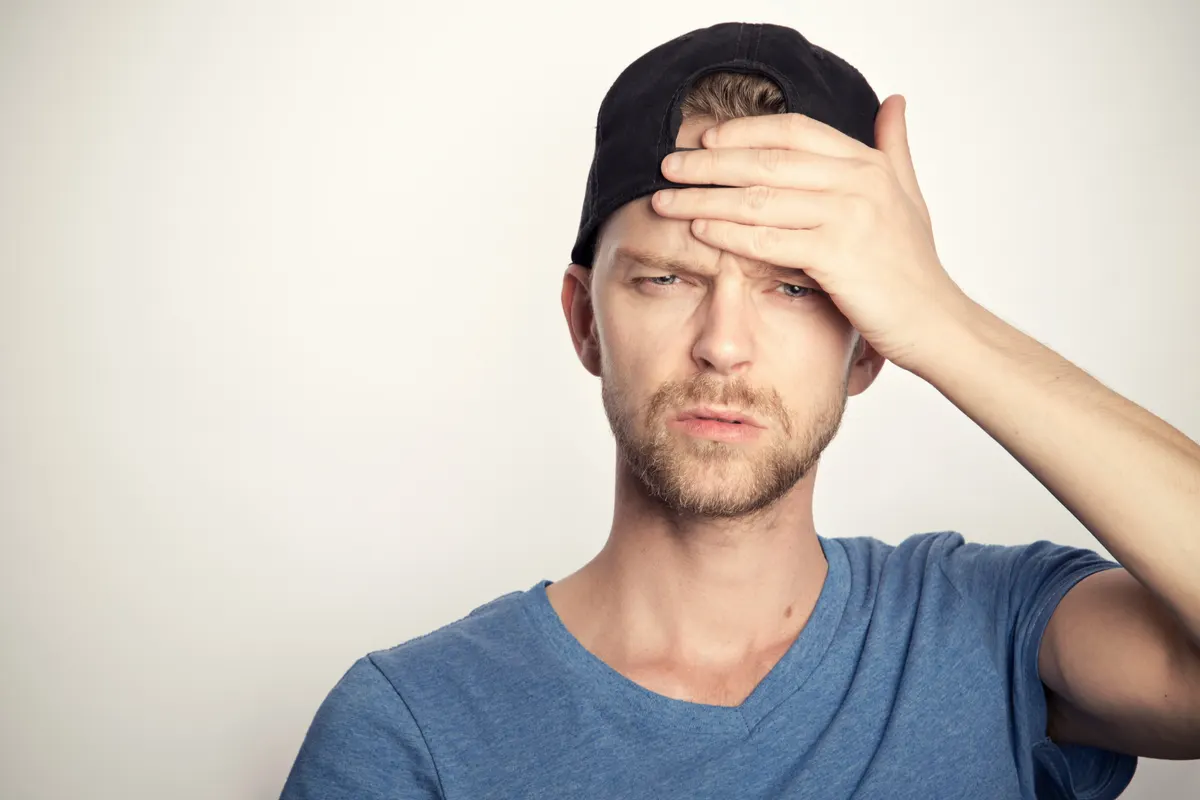Man with a hand resting on his forehead